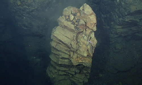 A column of magma intruded into the crust and cooled slowly after it was emplaced. It has been exposed and peeled away from the wall through subsequent tectonic rifting and erosion.