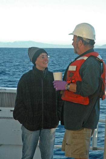 Carmen Castro and Tim Pennington chat on the aft deck while waiting for the CTD to resurface this morning. The coast of Baja California lies on the horizon.
