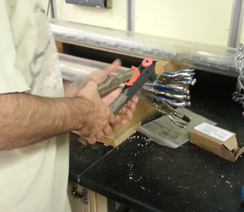 riveting in a core catcher onto the bottom end of a piston core barrel