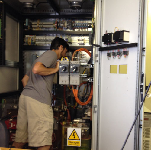 ROV pilot Bryan Schaefer inspects inside the ROV Doc Ricketts' power distribution unit (PDU) in the ship's dry lab.