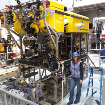 Research Assistant Kristine Walz stands next to ROV Doc Ricketts, which reaches well above 10 feet tall on top of the midwater tool sled.