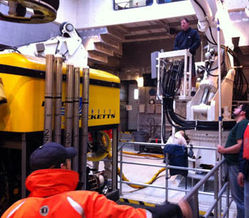 First Mate Erik Larson (top right) pays out the line that lifts the ROV after the recovery as Eric Martin (far right) and Ben Erwin look on.