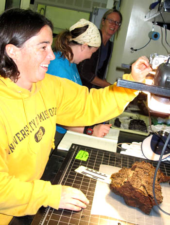 From left to right, Dorsey, Iliya Smithka, and Anita Englestad photograph, describe, and clean the rock samples after the dive.