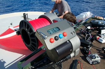 The operator uses this motorized winch to control the kite line, reeling the line in or out to position the kite.