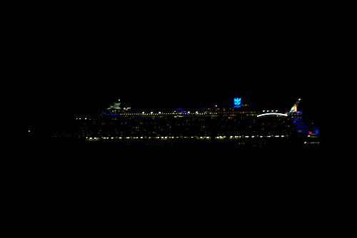 In the inky blackness of night, nearby cruise ships look like jewels on the water with their colorful lights.