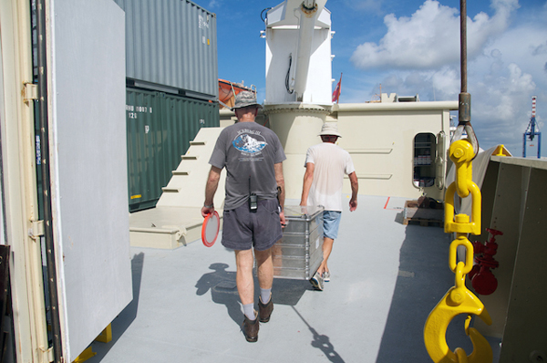 Chief scientist Ken Smith and engineer Fred Uhlman carry a box of equipment to the science lab. The main activities for the research team during the port stay are unloading equipment and preparing the working areas. The science areas of the ship are like an empty office space that has to be moved into. Sample jars and equipment get organized in the science lab; computers and printers are connected to the ship network; materials are checked and rechecked as this is the last opportunity to replace a broken or missing part. Everything also must be secured so that it doesn’t get damaged with the movement of the ship at sea.