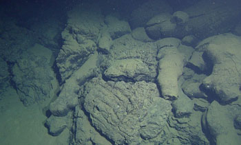 Contact between basaltic and higher-silica pillow lavas. The lavas to the right have a smooth surface and are relatively small. The lavas to the left are deeply grooved and large. 