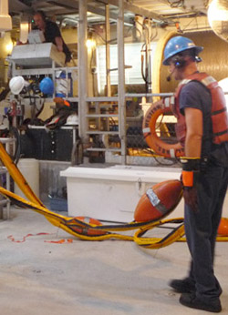 Chief Engineer Matt Noyes, top left, assists in bringing in the tether as ROV Doc Ricketts is recovered and Dan Chamberlain controls the ROV tether winch.