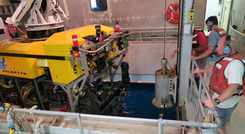 ROV pilots Knute Brekke and Bryan Touryan-Schaefer stand by as the crane lifts the Doc Ricketts into the moon pool.