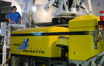 ROV pilots Knute Brekke and Bryan Touryan-Schaefer stand by as the crane lifts the Doc Ricketts into the moon pool.