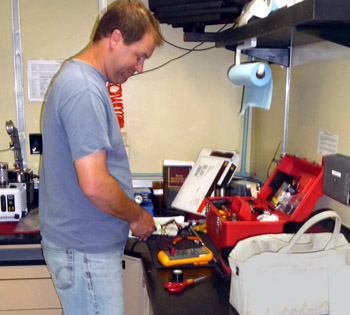 Peter Walz checks the voltage of a battery before attaching it to an instrument on the ROV.