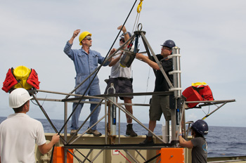 The heavy titanium housing containing the time-lapse camera system is lifted by crane into position and secured on the observatory frame. Photo: Debbie Nail Meyer