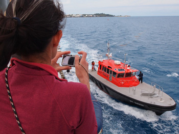Alana Sherman watches the pilot boat that accompanies the Lone Ranger as it is safely maneuvered beyond the reef areas that surround Bermuda. Photo: Carola Buchner