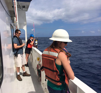 From left, Second Mate Trevor Daviscourt, Gabriela Chavez, and Monique Messié assist in deploying the sediment trap and buoy.