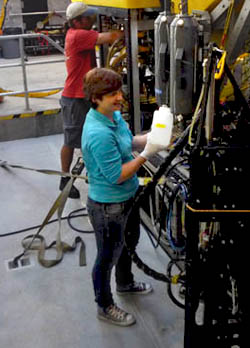 Kat retrieves water from the Niskin bottle after the dive. Victoria’s group will filter this water to look for methane-oxidizing microbes that live in the water column. Marko works on the Ricketts in the background. 