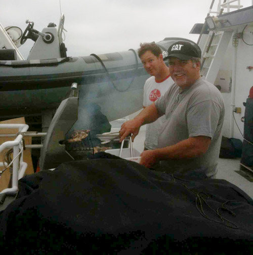 Erik Larson (left) and Lance Wardle on the back deck grilling a BBQ dinner on the evening May 21.