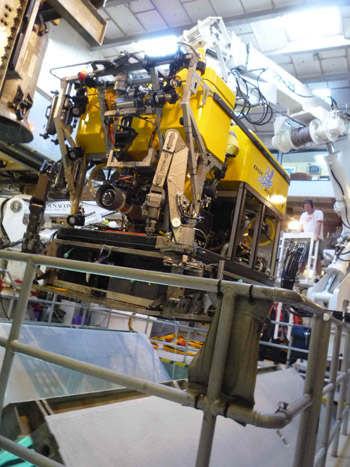 Erik Larson works the crane during the recovery of ROV Doc Ricketts. You can see the moonpool doors closing beneath the ROV.