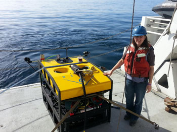 Kristine Walz next to the MiniROV, which stands just a few feet tall, but can be used as a fly-away vehicle in remote locations.
