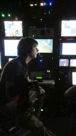 ROV pilot Ben Erwin operates the mechanical arm that is slaved to the manipulator on the submersible from the control room on the ship.