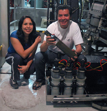Gabriela Cervantes and Martín Hernández Ayón with one of the push-core sediment samplers they took off the remotely operated vehicle. The two have had a few such mud samples to process every night; they carefully separate out sections of the core for later testing for trace metals.