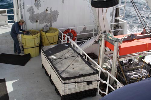 Engineer Bob Herlien programs the benthic respirometer system (at right) to measure the rates of oxygen consumption of seafloor animals placed in each of eight glass chambers. Each chamber has an oxygen sensor, stirring pump, flush pump, and an injection pump.