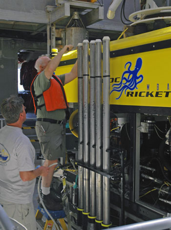 After each dive, Brian Edwards and Josh Plant work to offload and process the long vibracores from the ROV Doc Ricketts.