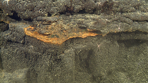layers of orange hardened sediment cap underlying lavas