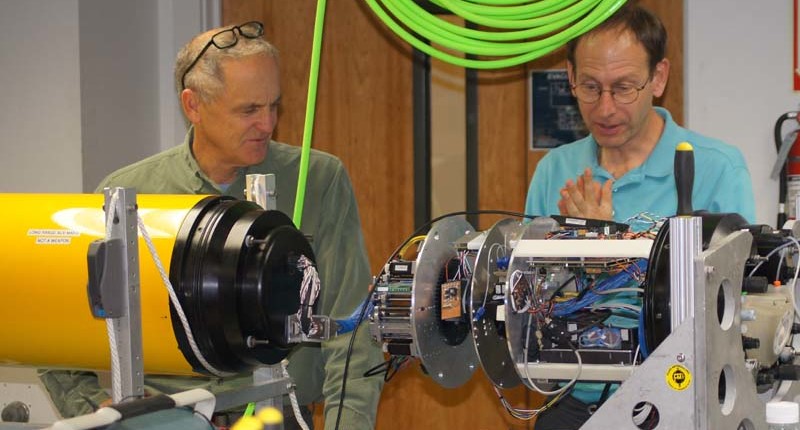 Engineers Brett Hobson and Brent Roman discuss the joining of the third-generation Environmental Sample Processor to the front of the long-range autonomous underwater vehicle.