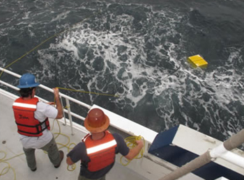 Surface recovery of the mooring starts by throwing grappling lines to catch the mooring line, and hauling the top syntactic foam floats to the ship.