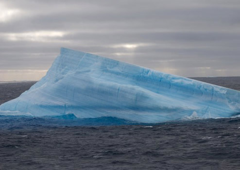 Layers of white and blue show seasonal freeze/thaw cycles in this iceberg fragment. Photo by Debbie Nail Meyer.