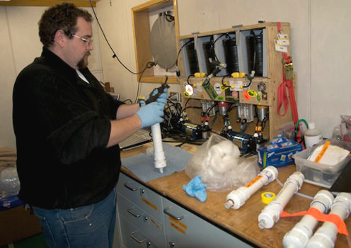 Chemist Cole Hexel places a radium sample in a cartrdge for analysis in the delayed coincidence counter in front of him. The instrument measures the time between the release of photons from the sample to identify radioisotopes. Photo by Debbie Nail Meyer.