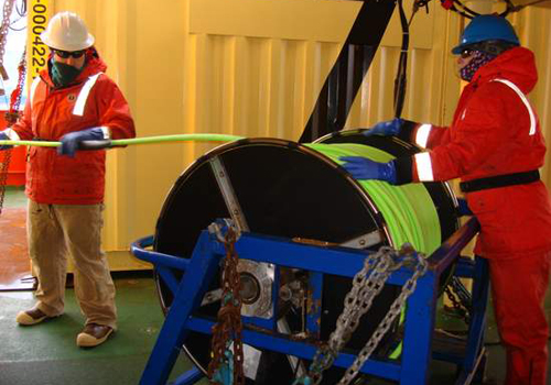 Jake Ellena and Debbie Meyer reel out tether as ROV IceCUBE dives deeper near the iceberg. Photo by Amanda Kahn.