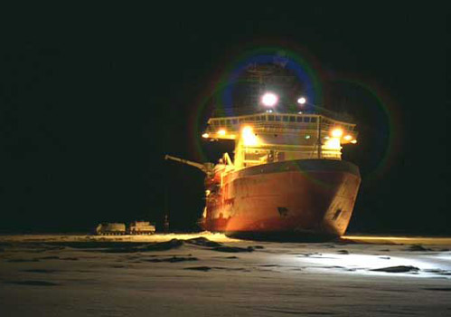 The RVIB Palmer broke through ice to deliver supplies to a research station. Note the trucks parked on the ice next to the starboard side of the ship. Photo by Mike Watson.