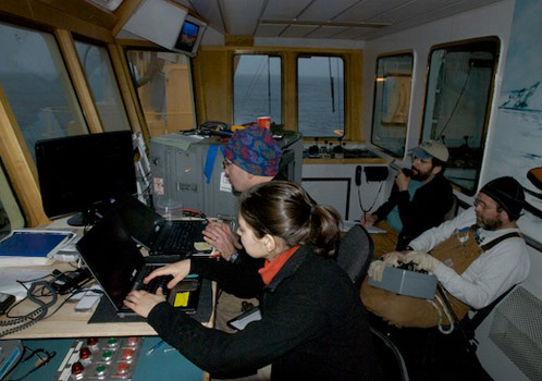 During an ROV dive, pilot Craig Dawe controls the vehicle using a lapbox. Engineer Paul McGill monitors system functions and communicates with the bridge and tether handlers on the deck. Stephanie Bush and Rob Sherlock operate the cameras and video system. Photo by Debbie Nail Meyer.