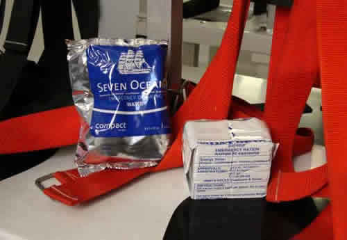 Rations for each person on the ship includes two water packets (left) for a total of 3 liters of water and one package of emergency food ration (right). Photo by Amanda Kahn.