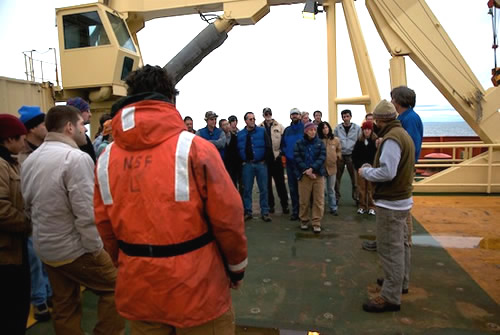 Marine technicians review deck operation safety procedures on the back deck during the the first day at sea. Photo by Debbie Nail Meyer.