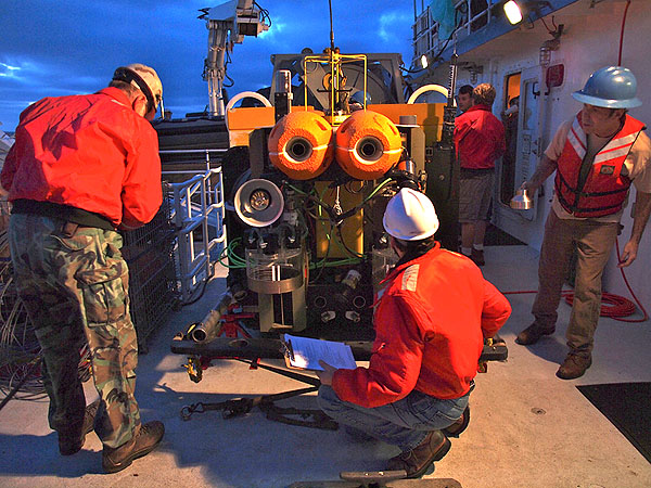 Ken Smith, Paul McGill, John Ferreira, and others not pictured prepare the Rover for its early morning deployment. Photo: Carola Buchner.