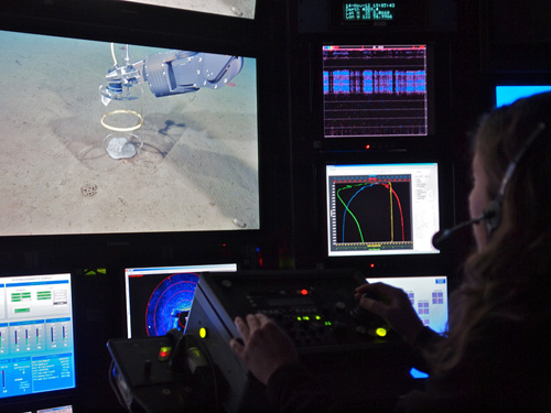 Amanda Kahn watches as ROV pilots carefully place a dye chamber over a plate sponge. The chamber will incubate the sponge in a fluorescent dye used for studying growth. Photo: Carola Buchner.
