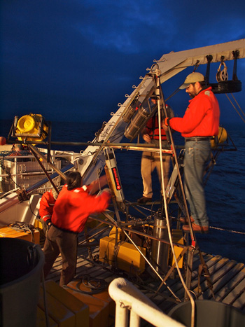Ken Smith, Alana Sherman, John Ferreira, and Paul McGill prepare the camera tripod mooring for its redeployment.  The tripod mooring will remain at Station M until the next cruise, gathering information about animal activity on the seafloor. Photo: Carola Buchner.