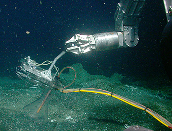 ROV Tiburon collecting samples of gas from a vent in the Guaymas Basin of the Bulf of California Tiburon Dive# 573 Lat= 27.59116173 Lon= -111.47509003 Depth= 1582.2 m Temp= 2.955 C Sal= 34.533 PSU Oxy= 0.47 ml/l Xmiss= 81.5% Source= digitalImages/Tiburon/2003/tibr573/DSCN2057.JPG Epoch seconds= 1052238215 Beta timecode= 02:28:23:19