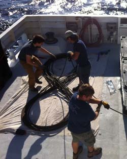 Ben Erwin, Mark Talkovic, and Randy Prickett coil 300 meters (985 feet) of damaged tether on the back deck.