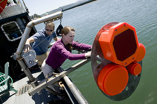 Kelly Benoit-Bird and Chad Waluk work on a sonar transducer system.