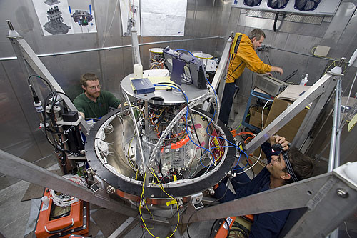 Engineers Doug Pargett, Wayne Radochonski, and Scott Jensen (left to right) performed tests on the ESP (in the center of the photo) before sealing it inside its pressure housing. The researchers tested the ESP inside of a refrigerated van to make sure that it would work in temperatures similar to those found in the deep sea (within a few degrees of freezing). Image: Todd Walsh © 2009 MBARI