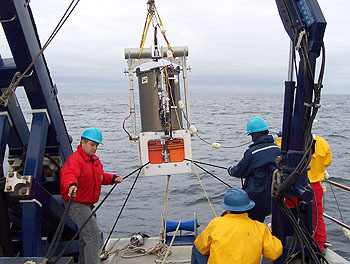MBARI researchers lower the Environmental Sample Processor (protected by a cylindrical waterproof housing) into the waters of Monterey Bay. Image: © 2006 MBARI