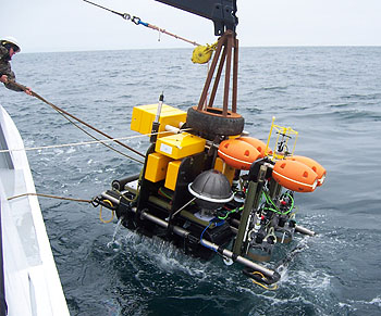 The crew of MBARI's research vessel Point Lobos lower the Benthic Rover over the side of the ship and into the waters of Monterey Bay. Image: © 2009 MBARI