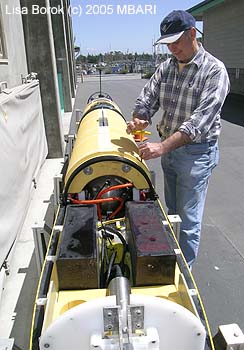 AUV specialist Duane Thompson working on the middle compartment of the mapping AUV, which contains the mapping sonar equipment. Image: Lisa Borok (c) 2005 MBARI