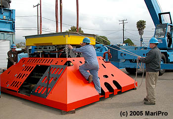 In April 2005, technicians at L-3 MariPro (a private marine technology firm) finished construction of the MARS science node. In this photo you can see that the node has two parts: a removable inner module (yellow) that contains all of the wiring and electronics and an outer metal frame (red) that protects the node from damage due to fishing nets. Image: (c) 2005 Nautronics MariPro