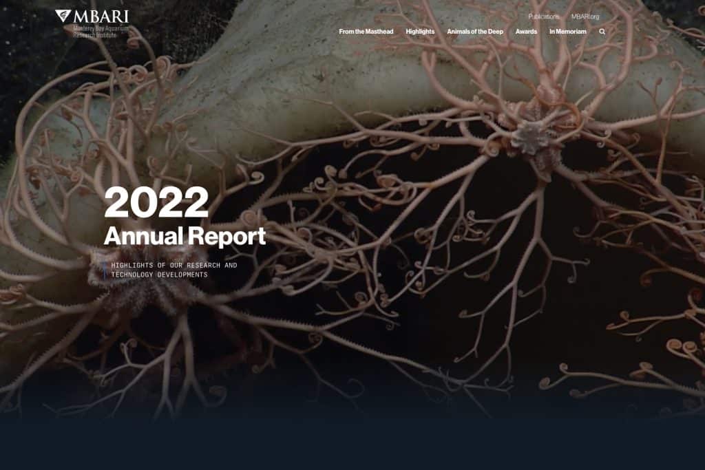 Screenshot of the landing page for MBARI’s 2022 Annual Report. The header includes the MBARI name and gulper eel logo, Publications, and MBARI.org. A line of tabs below includes From the Masthead, Highlights, Animals of the Deep, Awards, In Memoriam, and a search icon. The background is a photo of two peach-colored basket stars with coiled arms gripping onto the rim of a pale yellow sponge. The main text reads 2022 Annual Report: Highlights of our research and technology developments.