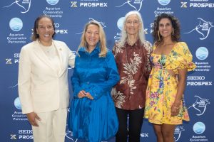 Four women pose for a photo at the 2026 Peter Benchley Ocean Awards. They are standing in front of a large blue banner with the event name and logo, with sponsor names and logos.