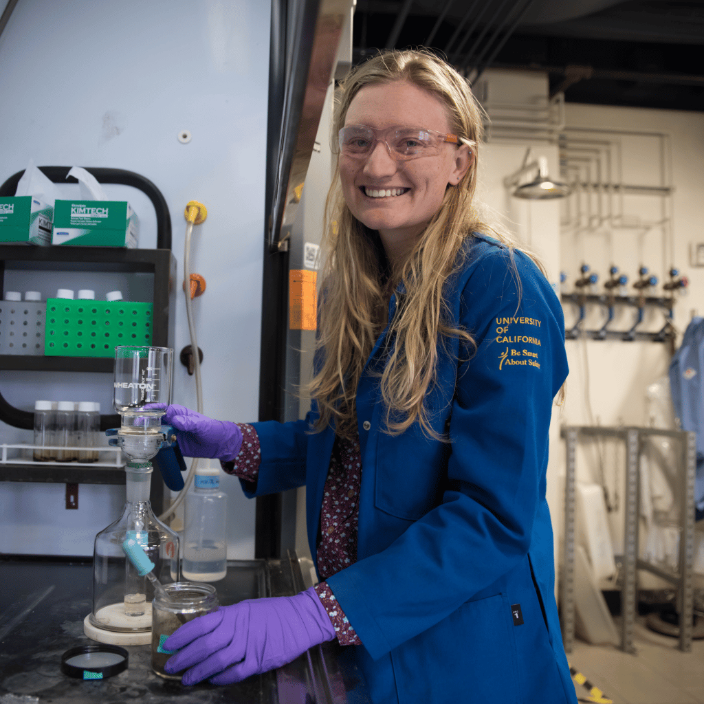 photograph of Dr. Alexandra Phillips working in the hood with gloves, safety googles, and labcoat